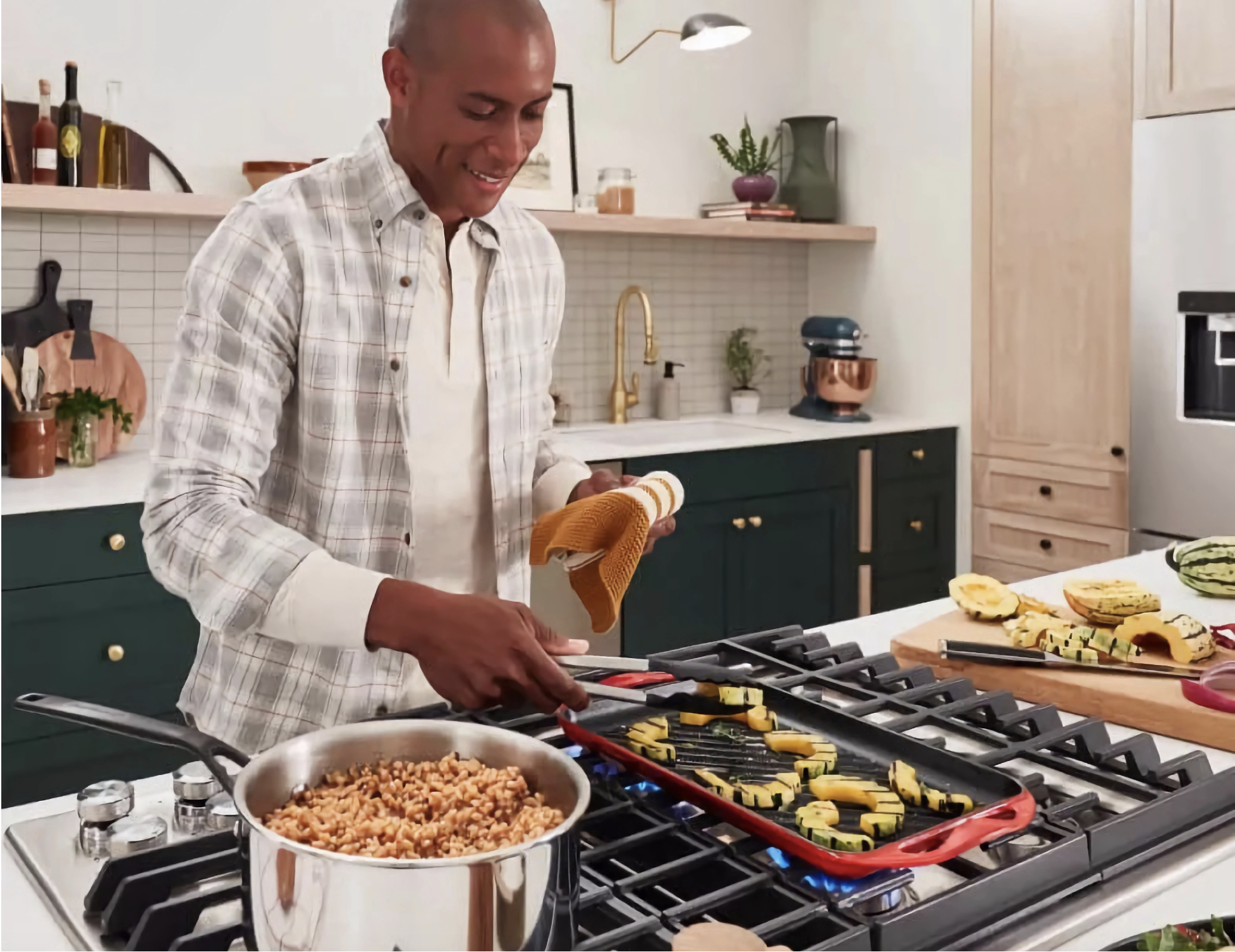 a man cooking at a KitchenAid cooktop built into a kitchen island